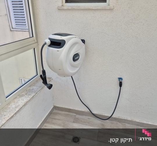 צינור מים מותקן על קיר ליד חלון